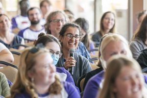 Person in a crowd asking a question with a microphone